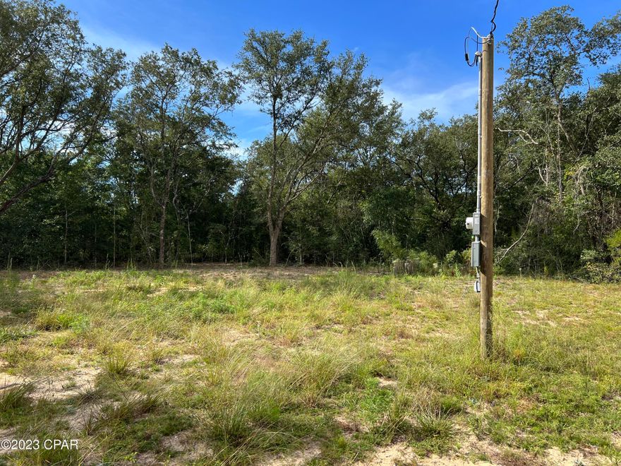 Nice Oaks high and dry 1.1 acre lot with Electricity and power pole.  Lot comes with a storage container. Good area of Compass Lake in the Hills.  There is a voluntary POA with a small fee which comes with benefits like use of the. swimming pool, Boat ramp, cabins discounts and more.  Conveniently located between Panama City and Marianna Fl. Come out here and get away from it all.   Lots of good fishing in the area.  Not far from I-10.