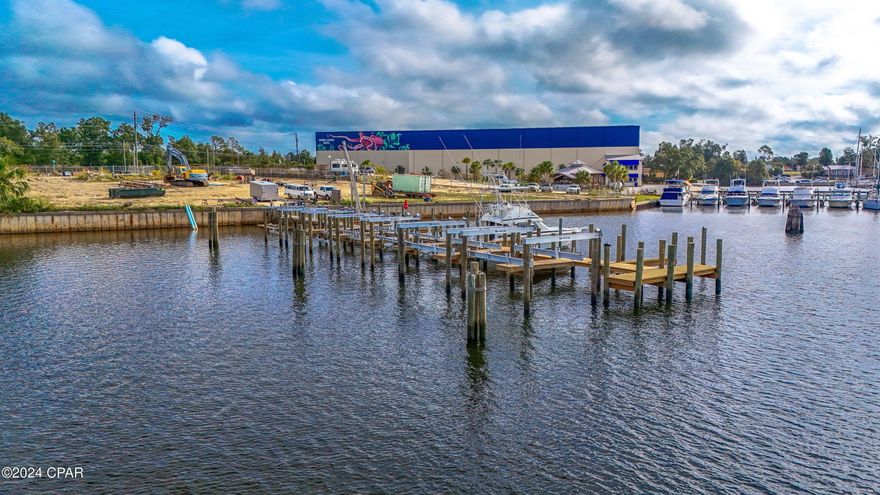 Great Location off Business Highway 98 with road and water frontage.  This Commercial Waterfront parcel Zoned GC-2 fronts Watson Bayou and sits next to the exclusive Watson Landings Marina for your boating needs. New 14 wet slips and custom lifts recently added with power and water to each slip.  Hydraulic lifts on slips.  More slips can be added going through the proper channels.  Can accommodate plus 40 foot boat. All utilities in place with city sewer and water,  as there used to be a dwelling on the premises prior to Hurricane.   Land has a seawall (250 ft) in place and a 136 foot long boat Dock (deep water access), to include over 250 feet of waterfront.     Excellent location and land size to build a storage facility, Retail, multi family or single-family  homes as it is zoned Commercial and Mixed Use.  Easy water access to Gulf with upscale marina next door for your boat fuel, storage and goods. New City Public Boat Ramp in close vicinity. Will seller finance if needed. Zoned Special Needs with tax incentives.