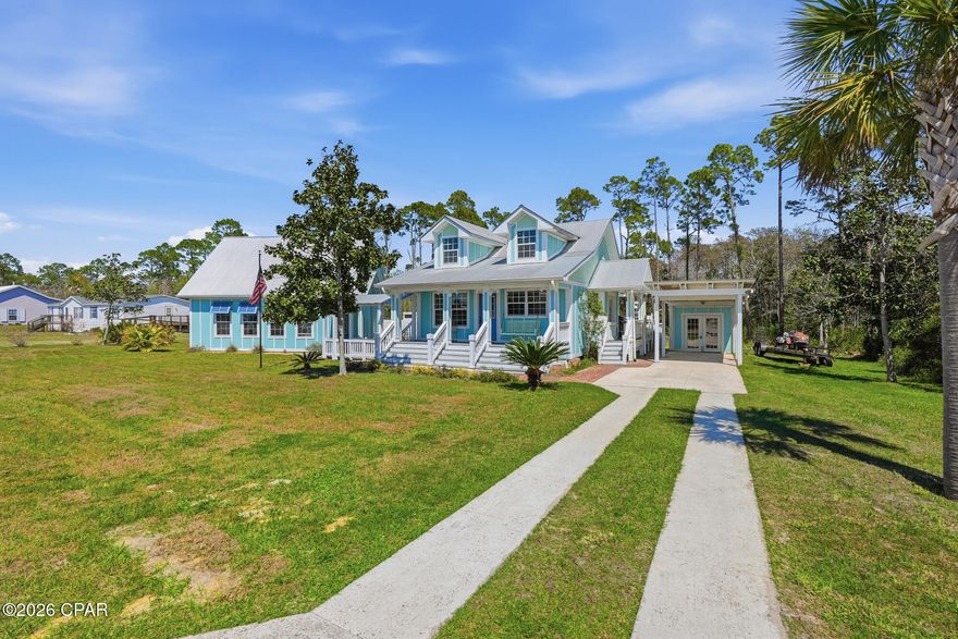 Just a short walk to the sugar-white sands of St. Joe Beach, this one-of-a-kind coastal property offers charm, privacy, and proven income potential on approximately ½ acre spanning two lots and backing to peaceful woods. Built in 2017 but thoughtfully designed to reflect a 1930s Florida cottage, the 2-bedroom, 1-bath main home features vaulted ceilings, an open-concept kitchen with pantry, loft with staircase access (potential additional living space), ductless mini-split HVAC, spray foam insulation, tankless water heater, and whole-house water filtration system. Authentic details include high wood baseboards, cast iron sink, push-button light switches, brass cover plates, solid wood doors, antique lighting, and exposed ribbed metal ceilings with acid-washed finish. Covered parking, golf cart parking, fenced yard, outdoor shower, and a covered walkway connecting to the garage add convenience. The detached oversized double garage includes a fully furnished 2-bedroom, 1-bath apartment with private entrance, currently operating as a successful Airbnb. A separate full-service RV site with 30/50 amp service, water, sewer, and private driveway operates as a Hipcamp rental. Combined rental income averages approximately $30,000 annually. Large entertainment deck, paver areas, storage building, pergola-style canopy, and wooded backdrop complete the setting. With two lots included, there is potential to add a pool, build a workshop, construct another home, or sell off the back lot (buyer to verify). A rare opportunity for a primary residence, vacation retreat, or income-producing investment near the beach.