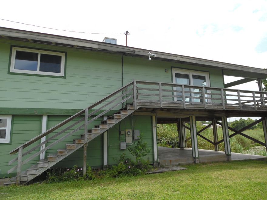 Don't miss this opportunity to get a great buy on a beach house!  This home is located just 1.5 blocks from the sugary white sandy beaches of Panama City Beach.    The upstairs boasts exposed-beam architecture, with  2 bedrooms and an open-concept greatroom and  tons of floor to ceiling windows that showcase both waterways, lake and Gulf.  Step onto the balcony and there is a nice breeze coming off of the small lake and a peek-a-view of the Gulf of Mexico.  There is covered parking beneath the house and lots of storage closets for all your beach toys.  The rear patio is concrete, covered, and perfect for a hammock and afternoon naps.  Rarely is a deal like this one available, so close to the beach, so call your favorite Realtor today.