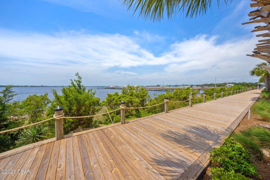 Positioned on the water in historic St. Andrews, this condo has a beautiful view of the Panama City sunsets from its position on the southwest side of the 7th floor.  Craft food and drinks, community events, and more are withing walking distance through the mature oak trees and historic buildings.  Located 8 minutes to Gulf Coast State College and the FSU extension, less than 10 minutes to the down town business district and 15 minutes to Panama City Beach, this unit is conveniently located.  Ample covered parking, private board walks, a large swimming pool, fitness center, a large banquet hall with a full kitchen, and conference center are all available to owners. This is a newer complex, built in 2005, and has just recently been renovated. Once you approach this unit you will notice the ample room at your large double entry with room for a sitting area. Once inside, you will find high ceilings, luxury vinyl plank floors, a wide foyer with two large bedrooms on either side. These bedrooms feature tall ceilings, fresh paint, and elegant finishes. Both bedrooms also boast freshly remodeled bathrooms. As you make your way to the kitchen, you will notice the endless counter tops, a large pantry, and high-end appliances with plenty of space to entertain guests. The custom cabinets, featuring soft close drawers and door, are full of creative storage options. This immaculately maintained home is perfect for get togethers with room to relax and soak in the views in the living room all the way out to the balcony. The presidential sized primary bedroom is large and overlooks the bay with access to the large private balcony. Beyond the French doors you will find a grand bathroom featuring a grand shower with double vanities set in custom cabinets and matching countertops. You will also find 2 large closets for plenty of storage. Throughout this unit you will find elegant crown molding, craftsmen styled window trim, and thoughtful finishes. This unit also features a new HVAC system, new water heater, and new windows facing the water.