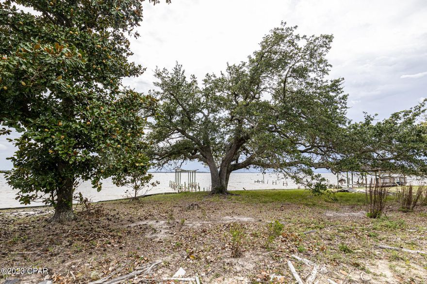 Beautiful waterfront lot with deep water access located off East Bay. Build your dream home and enjoying beautiful sunsets sitting on your back patio or dock. This lot/land is located off Highway 2297 and had a 3 bedroom, 2 bathroom house with approximately 1,787 sqft of floor space.  Spacious .61 acre lot also had an inground pool at one time. The lot still has mature trees and bushes. Less than a mile to Eastern Shipbuilding and 20 miles to Tyndall Air Force base. Dock pilings and lift are intact for an easy rebuild. Seawall is in good shape, will need minor work to restore. Deep water well and septic are on site but will need to be tested and connected. Call your favorite Realtor® for a showing today.