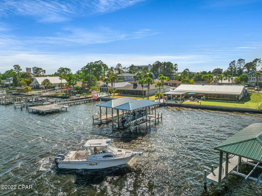 Imagine living just steps from the water, this house is your opportunity to truly live the Florida lifestyle, whether making 6112 S Lagoon your primary residence or your second home this timeless water-front estate is a one of a kind. Featuring 100 feet on the water, your own dock with a double boat houses and sun deck, five-bedrooms, four-bathrooms, and a bonus room. Throughout this home there are several eye-catching features such as the vaulted beamed ceilings, central fireplace, and a summer kitchen but nothing beats the waterfront views from the oversized Florida room. The stunning Grand Lagoon is viewable from many rooms in this home. In the spacious master bedroom, you will find high ceilings, an elegant his and hers bathroom, walk-in closets, garden tub, and walk-in shower. through this bedroom you will notice the custom finishes, craftsmen solid wood doors and quality hard wear. The accordion plantation blinds open allowing you to take in the gorgeous views from anywhere in the room. One of the most desirable aspects of this home is the stout durable construction. This is a home that can last the test of time, with Terrazzo floors, concrete block walls, insulation pellets throughout the block cavities, Bahama shutters, a heavy gauged metal roof over 3/8 plywood sheets, 3 HVAC systems, gutters, ample storage and even a drain in the garage. This home is perfect for entertaining with so many options for seating, both inside and outside. For the boat enthusiast you will be happy to know that this home sits on one of the deepest parts of the lagoon, at the time of the listing, the listing agent measured over 6 feet of water depth under the boat house! This is truly a one-of-a-kind home.