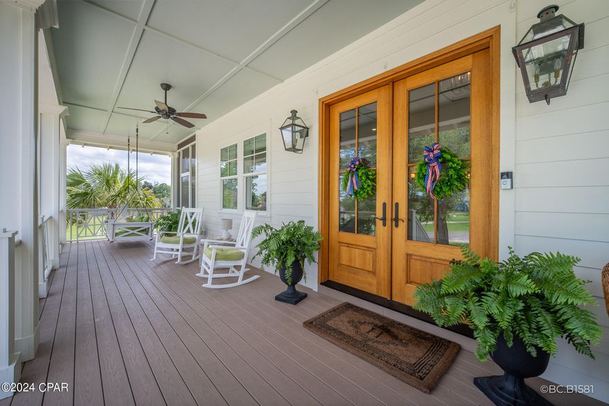 A rare 2020 Windolf-built estate on a .91-acre double lot inside the city of Port St. Joe, with panoramic views of St. Joseph Bay from every principal room. The kind of home that does not become available -- engineered for permanence and built to be passed down. Constructed to last generations: reinforced concrete foundation, full block-and-Hardie exterior, foam insulation between every interior room, hurricane-rated impact windows, standing-seam metal roof, whole-house generator, tankless water heater, natural gas, irrigation well, and underground utilities. Inside, craftsmanship reads immediately. Ten-foot ceilings, mahogany double-door entry, wide-plank Carolina Pine COREtec and hardwood floors, plantation shutters, and custom millwork throughout. The chef's kitchen features fully custom cabinetry, professional gas range with vent hood, wine refrigerator, oversized island, and walk-in pantry. A gas fireplace and built-in bookcases anchor the living room beneath French doors framing the bay. Formal dining and wet bar extend the entertaining footprint. The primary suite is a private retreat with sitting area, two walk-in closets, spa bath with garden tub, separate tile shower, double vanities, and screened porch access. A full elevator serves all three levels, and the home was designed for full wheelchair accessibility, including ADA-compliant baths, without compromising elegance. Three additional bedrooms, a bunk room, game lounge, and workshop provide flexible room for guests and hobbies. Wraparound covered and screened porches run the full length of the home. Mature live oaks, magnolias, palms, and fruit trees frame a circular drive to a three-car attached garage. RV sewer hookup, outdoor shower, and a prepared outdoor kitchen site are in place. Nearly an acre of level, walkable land -- a near impossibility inside city limits -- minutes from downtown, the marina, and Cape San Blas. Most furnishings negotiable. 3D Matterport tour available. Showings by appointment.