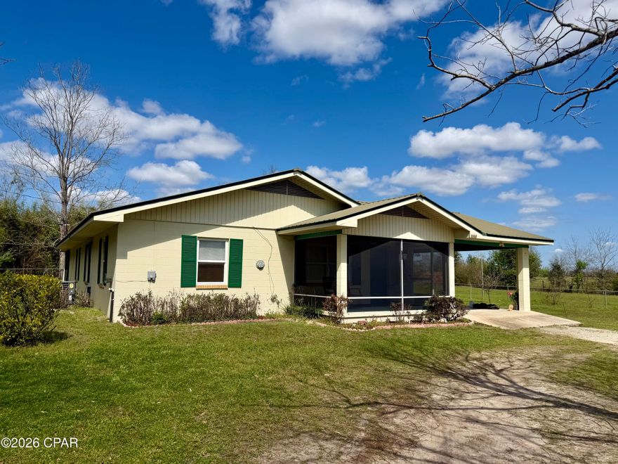 Check out this 2 bedroom, 2 bath concrete block home offering comfort, character and plenty of outdoor space!  The spacious living room features a cozy freestanding wood-burning stove, providing an energy-efficient heat source. An arched doorway leads into the dining area, adding a touch of character to the home's layout. The kitchen is open to the living room and includes a breakfast bar, pantry with convenient pull-out shelves and windows that overlook the side yard.  A bonus room off the kitchen offers flexibility and could easily be used as a home office, hobby space, or additional storage.  The master bath features a step-in shower with handicap bars already in place.  Enjoy the outdoors from the inviting front screened porch, complete with a swing that practically calls for relaxing afternoons. The large back screened porch is the perfect place for entertaining family and friends.  This property also includes multiple outbuildings including a storage building, a storage building with a two-car carport, an old barn, chicken coop, and a small carport built for an ATV.  There's even room for animals--the owner has previously kept a horse in the side pasture.  The property also features satsuma and peach trees, along with plenty of space for a garden.  If you've been dreaming of a peaceful country lifestyle with space for chickens, animals and a garden, this property could be the perfect fit!