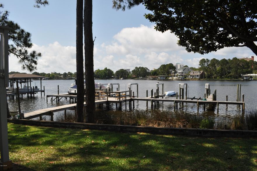 Waterfront condo on Grand Lagoon with a designated boat slip! This is a 2BR/2BA unit on the first floor of Quarter Deck condos. This newly updated condo features tile flooring, stainless steel appliances, walk-in closets, and a private balcony.  This is an immaculate end unit in a low density, low maintenance complex that does NOT allow short term rentals. Park your boat right outside your back door and you're only minutes from St. Andrews Pass and the Gulf of Mexico! All info is approx. and must be verified by Buyers if important