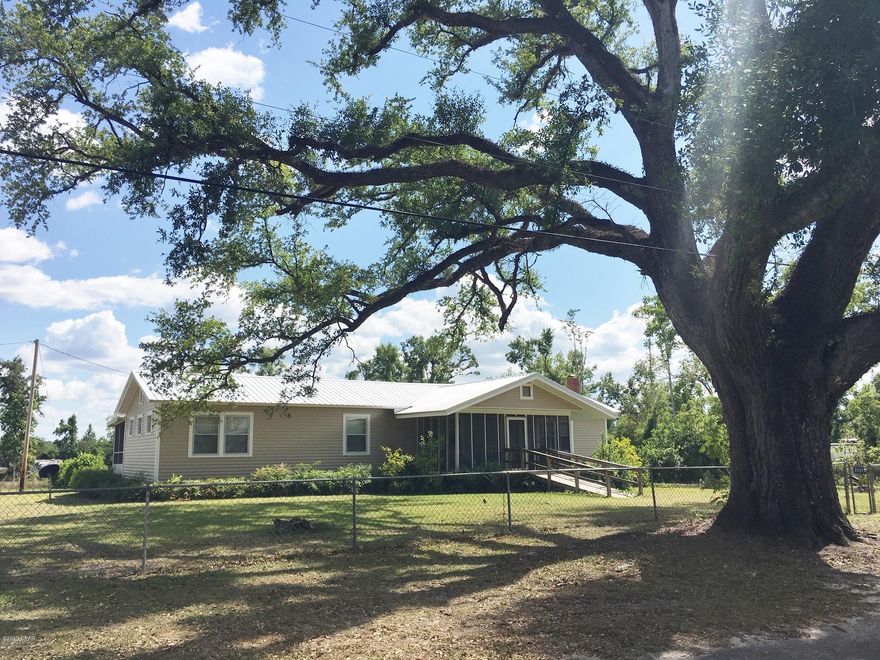 Brand new vinyl siding has been added over the original wood exterior to this home, garage and wash house. A little age but a lot of character and amenities and privacy.  3BR/2B sitting on over 2 huge , fenced acres in Alford. Fenced city block, outbuilding/shop, Detached garage, RV shed and plenty of gardening space. The home has front and back screen porches, original oak hardwood floors, central heat and cool, fireplace and much more. This home is ready for you to move in.  The home has public water and also a well used for garden or outside uses.