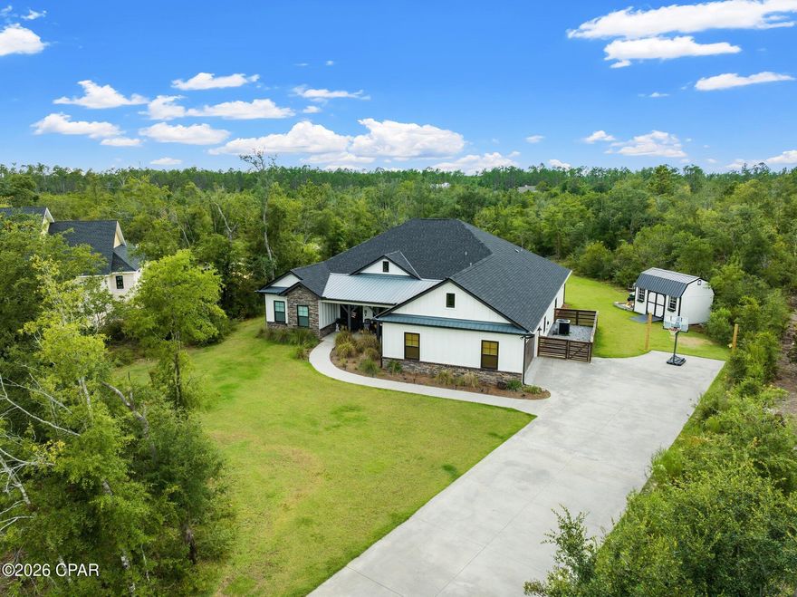 Welcome to this beautifully crafted custom home offering 2,912 square feet of thoughtfully designed living space on a private 1.74-acre lot in a desirable gated community. Built in 2018, this 4-bedroom, 3-bath residence combines modern comfort with timeless style, all just a short drive from Panama City Beach.

Step inside to an open-concept layout featuring 10-foot ceilings, abundant natural light, and high-end finishes throughout. The heart of the home is the spacious kitchen with an oversized 10-foot island, seamlessly flowing into the living and dining areas--perfect for both everyday living and entertaining. A cozy brick fireplace anchors the living room, while LVP flooring runs throughout the main areas for durability and style.

The oversized primary suite offers a private retreat with direct access to the screened-in back porch, creating a seamless indoor-outdoor living experience. The en-suite bath features a walk-in shower with bench and a 6-foot soaking tub, while secondary bathrooms include upgraded 5-foot soaking tubs. Additional spaces include a dedicated office and a fully equipped movie room, providing flexibility for work, relaxation, and entertainment.

Enjoy quiet mornings on the covered front porch, complete with a charming porch swing, or unwind in the spacious 18x10 screened-in back porch overlooking your private, wooded backyard. The outdoor space is truly one of a kind, featuring a custom tree fort and obstacle course tucked into the woods--perfect for adventure and creating lasting memories.

The home's exterior showcases a beautiful blend of stone and board-and-batten siding, enhancing its curb appeal. Located within a gated community offering a pool, clubhouse, playground, and private dock access to Deer Point Lake, residents enjoy both privacy and convenience.

This property also features an assumable VA mortgage at an exceptionally low 2.25% interest rate--an incredible opportunity for qualified buyers.

Don't miss your chance to own a unique property that offers space, privacy, and lifestyle all in one.