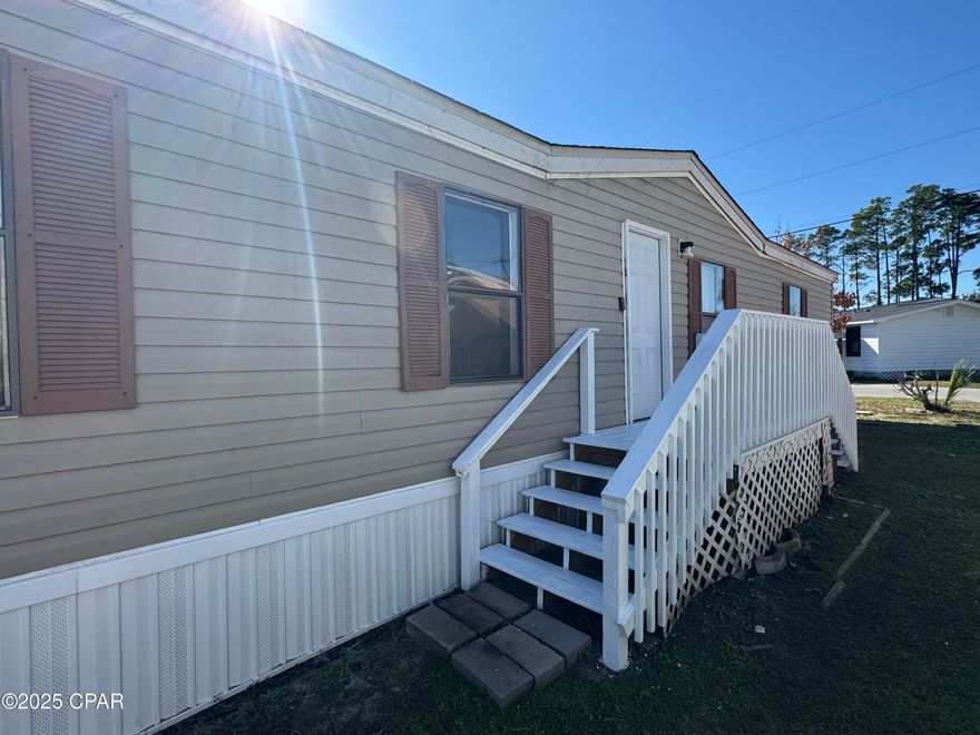 Welcome to this spacious 3-bedroom, 2-bathroom double-wide home set on a desirable double lot in Bayside Park, just steps from a full service marina that offers  launch services, plus RV and boat storage. Walk into an open living and dining room layout filled with natural light. The updated kitchen features brand-new cabinets, refrigerator, and dishwasher, along with wood look tile flooring and an island that overlooks the living room and sitting area—perfect for everyday living and entertaining.

The split floorplan offers great privacy. The primary bedroom includes double windows, a walk-in closet, and an en-suite bathroom with a new vanity and a relaxing jacuzzi tub/shower combo. On the opposite side of the home, you'll find two additional bedrooms with walk-in closets and a full bathroom with a tub/shower combo and a new vanity.

Recent upgrades include brand-new central AC, a new water heater, new skirting, and LVP flooring throughout the main living areas.

Just past the kitchen is a dedicated laundry room, and out the back door you'll enjoy an enclosed Florida room with windows and a glass door that faces the marina—an ideal spot to relax and take in the coastal breeze.

This home is move-in ready and simply waiting for the new owner to add the finishing touches. Located in Bayside Park, you'll be minutes from Bay County Skate Park, Publix Sports Park, Duplin Winery, Gulf Coast State College, Pirates Voyage Show and all the shopping and dining along Front Beach Road.

Fireplace conveys ''as-is''. Functionality and condition are unknown. This home will make for a make for a great primary home, but could be utilized as wonderful vacation getaway or short & long-term rental investment property.

All measurements and lot dimensions are estimates only-Buyer or Buyer's Agent to verify if deemed important.