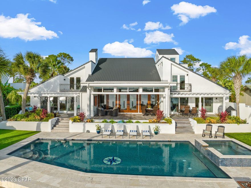 Exceptionally Luxurious and Fully Furnished Bayfront Home with Tropical Poolside Oasis! Nestled on a 0.39-acre lot in the exclusive gated community of Bay Point, this 6BR/6.5+BA, 6,075 SF residence offers a feast for the senses with astonishing panoramic waterfront views from nearly every room in the house, lush landscaping, private automatic gated entry, and exquisite contemporary Mediterranean architecture. Drenched in natural light, the smart home dazzles with an organically flowing floorplan, gorgeous hardwood flooring, soaring vaulted wood beam ceilings, a curving staircase, and an expansive living room featuring a well-appointed fireplace and triple French doors which lead to the elevated deck. Explore further to discover an open-concept gourmet kitchen, which includes commercial-grade stainless-steel appliances (Wolf and Sub-Zero), quartzite countertops, custom white shaker cabinetry, two islands, (6) drawer refrigerators/freezers, gas range, double wall ovens, two dishwashers, built-in wine refrigerator, fireplace, wet bar, breakfast nook, and an adjoining formal dining area. Brilliantly oversized for unsurpassed relaxation, the main-level primary bedroom boasts a romantic fireplace, coffered ceilings, serene water views, oversized 4 panel sliding glass doors, a massive custom closet, and a sumptuous en suite boasting a standalone soaking tub, fireplace, dual vanities, a large rain shower, and two water closets. Three of the four guest bedrooms feature waterfront views, two of which are main-level with sliding glass doors leading to the deck; the third includes a waterfront balcony. With three of the guest bedrooms including en suite bathrooms, this is the home that never stops giving. Incredible entertainment opportunities abound in the phenomenal outdoor space, which has 90' of water frontage, an enormous heated pool, a hot tub with waterfall feature, natural gas firepits, sprawling decks with multiple outdoor dining locations, and impeccable landscaping with in-depth accent lighting. Smart home features include the Leviton SnapLink app which controls 150+ switches, 12 zones of Sonos audio, 8 remote thermostats, full home surveillance and motion security, water leak monitoring, remote pool controls and so much more. Other features: 5-car garage, 3rd-floor observation room/sunroom, full house generator, 30 amp service on the dock, and dual jet ski floating dock.