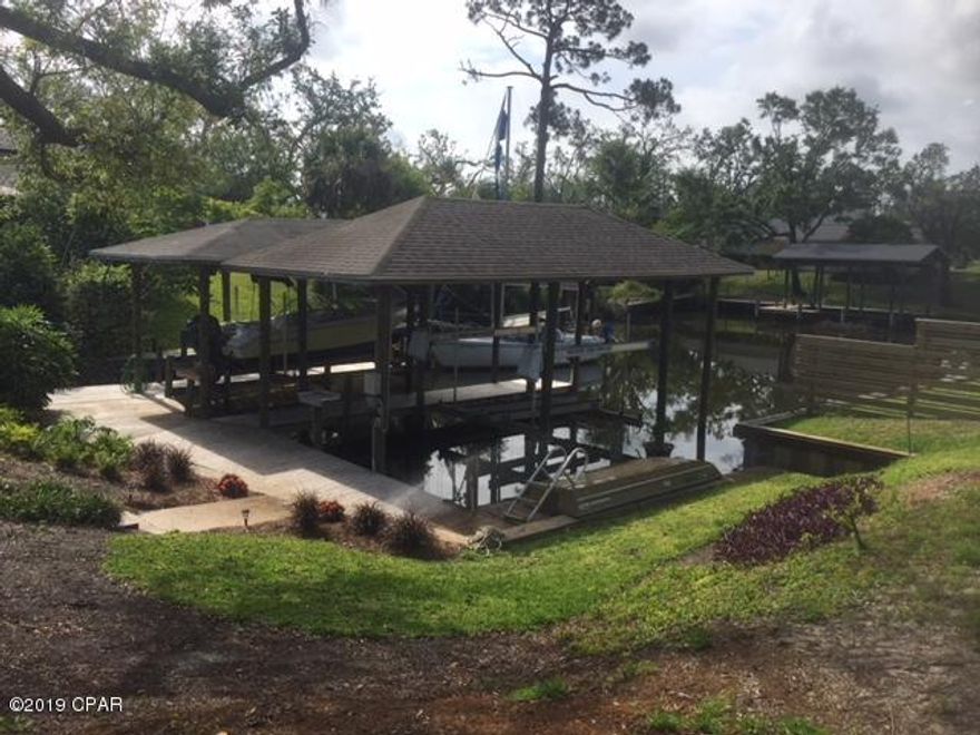 CURRENTLY UNDER CONTRACT, SELLER ACCEPTING BACKUP OFFERS.  Minimum hurricane damage in this well protected, waterfront, hurricane hole.  This is a boaters home w/12,000 lb lift, boathouse & dock.  Home is on deep canal, 5 minutes by boat to FSU PC, est 15 minutes to the pass/Gulf.  ALL REPAIRS COMPLETED incl. new 50 yr transferable warranted roof, seamless gutters & downspouts, ext. professionally repainted with PPG brick paint, new front leaded glass double doors, repaired N-facing exterior trim.  Has long, doublewide cement driveway to park lots of toys.  New double-sided privacy fence to give you & the neighbors quiet.  You will love this 3BR/2BA home with huge Master Suite with incredible bath, and a Chef's kitchen, 28'' travertine tile floors, carpet in bedrooms, crown molding. sinks, tubs, master separate shower and Garden Tub, granite countertops, double pantries, double entry doors, solid interior doors, Bosch stainless appliances, complete HVAC and water heater....all new.  The Florida Room is as big as a garage and there's a canvas sail awning outside the plexiglass garage door. Beautiful landscaping with deep well for watering grass and shrubs, treated for indoor use/city water is available at the street.  Room for a pool.  Neighborhood getting pretty with repairs, new lawns, one by one.  MOVE IN READY,  EVERYTHING IN GREAT SHAPE,  NEW PRICE,  SERIOUS SELLER/MAKE OFFER.  Don't hold out too long, this one will go to long term rental, soon, should there be no contract.  All info is approx. and must be verified by Buyers if important.