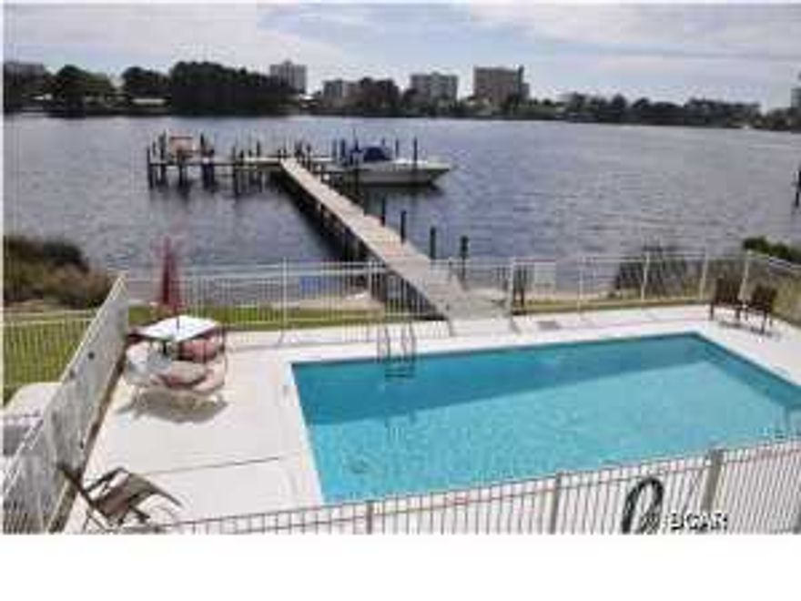 Ready for some fun in the sun? This waterfront townhome comes with a boat slip with lift! Located on Grand Lagoon, you're only 10 minutes from Shell Island and the Gulf of Mexico. The unit is very roomy and well-designed with plenty of storage for all your beach and fishing gear. The sellers just added new tile downstairs, new carpet upstairs and updated some of the fixtures in two baths. In addition, there is a balcony off the Master Bedroom and the unit includes a one car garage. Just a few steps out of the back door is the community pool and of course, you can always fish right from the dock! This is a perfect weekend retreat for those who don't want to deal with traffic, noise and long waits at elevators. All info is approx and must be verified by Buyers if important.