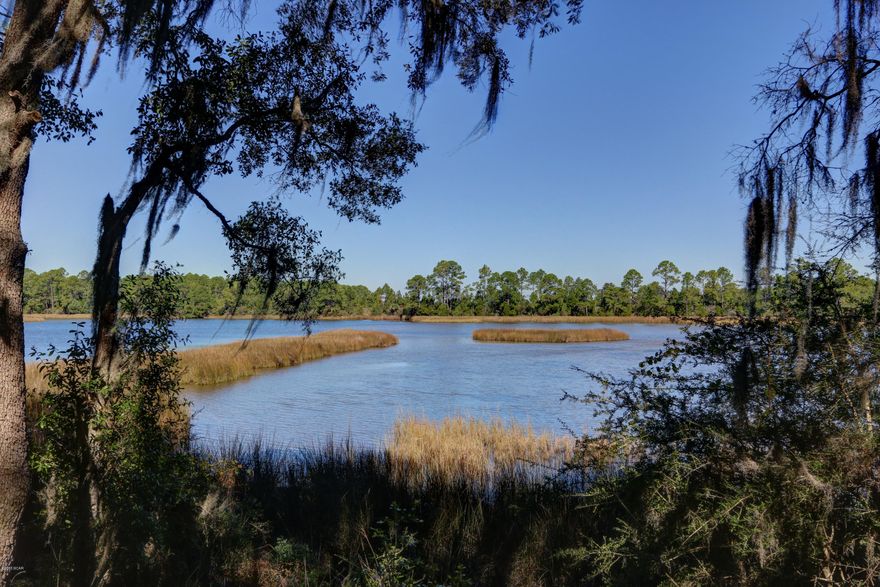 Custom built home which was designed to get the best views of the water from each room. This amazing property actually has two structures under one roof, which was the way the architect designed the home, the main house has 3 bedrooms and 2 baths and the additional structure which was used as a home office could easily be converted to a mother-in-law suite, etc.  As you enter this home you will be immediately drawn to the beautiful Italian tile flooring and the very spacious glass entryway joining the house and the additional structure. Home was designed for entertaining, very large kitchen, two huge pantry's, cabinet and counter's galore, breakfast nook with built in's making it a perfect to display your china, then you enter the extensive living room with sliding glass doors looking out to the water, more built in's and a fantastic fireplace. All bedrooms and bathrooms are very spacious, master offers his and her large walk in closets compete with a nice nook to enjoy a good book in the evening.  The home office has it's own entry way and there you will find two large rooms and a full bath with another view of brilliant sunsets, this part of the home is separately contained, again offering so many possibilities for it's use.  Property is situated at the end of a quiet cul-de-sac with mature shade trees such as towering oaks gently draped with Spanish moss surround the lot offering plenty of shade making this truly a one of a kind home,  there is not a better place in Lynn Haven to enjoy the 4th of July Fireworks than at the end of the dock, call for your private showing today.   All ages, sizes including sq. ft. are approximate measure if important.