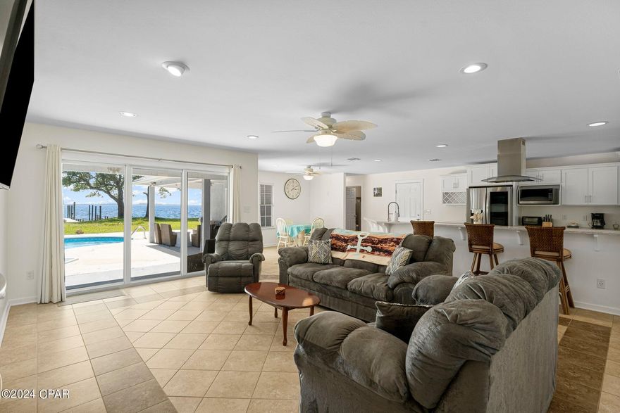 Welcome to this spacious waterfront home on the open bay, offering approximately 2,500 square feet of living space. This beautiful property features 4 bedrooms, 2 bathrooms, and an inviting in-ground swimming pool. Inside, you'll find a cozy family room with a fireplace, perfect for relaxing evenings, and a fully equipped kitchen with a breakfast bar, ideal for casual dining and entertaining. The formal dining room is perfect for hosting family dinners and special occasions. The luxurious master bedroom boasts a walk-in closet and an en suite bathroom with a double vanity and a separate shower. Outside, the large covered rear porch provides a perfect space for outdoor relaxation and enjoying waterfront views. Additionally, the home includes a double garage with pull-down stairs for convenient attic access and extra storage. Don't miss this opportunity to own a stunning waterfront home with all the amenities you need for comfortable living. Thank you for considering this home.