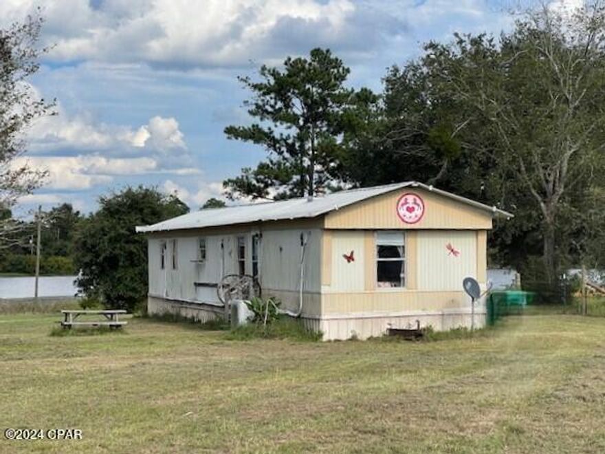 **PRICE REDUCED**  LAKEFRONT - Perfect weekend getaway!  Cute manufactured home on 1.32 acres on Lake Susan at the Highlands of Compass Lake. The owners have done some updates to make it a very comfortable place to live, rest and relax in. You have room here for horses, chickens, etc.  They created a lovely orchard that includes 3 banana trees, 1 avocado, 1 fig, 1 nectarine, 4 olives, 1 peach and 1 lime. There is an underground irrigation system.   They have installed a mini-split A/C - heat system in 3 zones that is very efficient.   It would make a neat permanent home  for a couple or small family.  Also included is a hook-up for a camper.   An 8x8 outbuilding remain.   All appliances stay as well as a nice washer and dryer.  Some furnishings also stay.