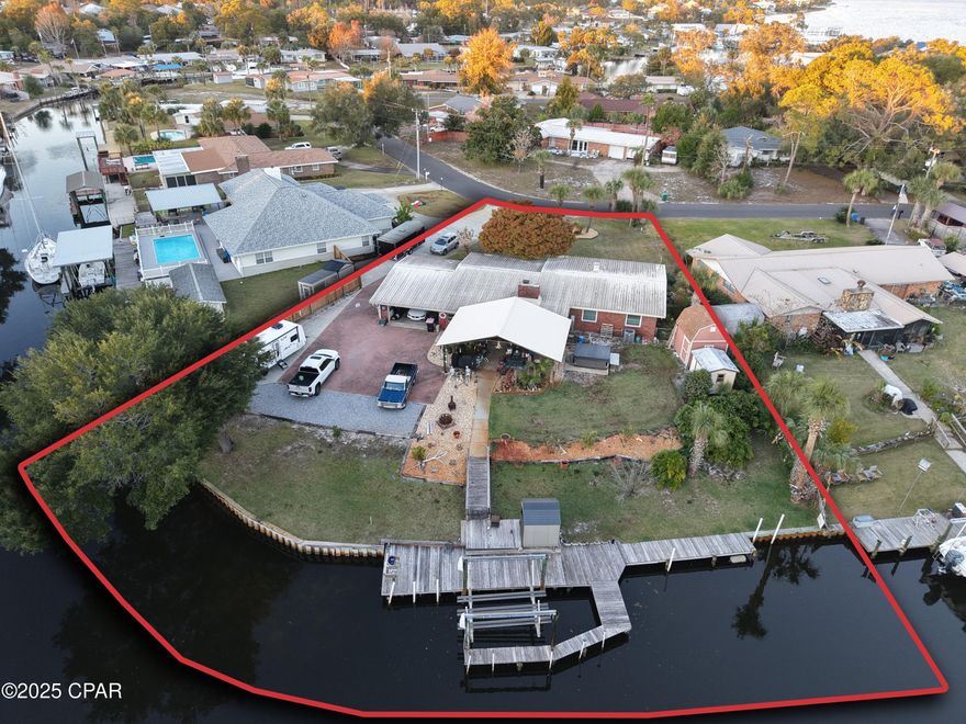 Designed for those who live on the water, this exceptional canal-front residence delivers true boating functionality paired with timeless Florida architecture. Set on an oversized waterfront parcel with excellent canal depth and direct access to the Gulf, this home offers the infrastructure, flexibility, and scale serious boaters demand.

The private dock is equipped with a heavy-duty metal I-beam boat lift powered by a ¾-horsepower electric motor, capable of accommodating vessels up to 30 feet (currently configured for a pontoon). Canal depth averages approximately 5-6 feet at center, offering long-term adaptability for a variety of boat sizes. With ample seawall frontage (191') and maneuvering space (80' canal width), this property is ideal for both recreational and seasoned boat owners.

Inside, the home provides generous living and dining spaces perfect for entertaining after a day on the water. The renovated kitchen (2015) features granite slab countertops, a farmhouse sink, soft-close cabinetry, a spice cabinet, and a casual breakfast nook designed for both efficiency and comfort. A built-in minibar with sink and custom cabinetry enhances the home's hosting capabilities.

Three bedrooms, two full bathrooms, and a convenient half bath near the garage offer flexibility for guests and extended stays. A sun-filled Florida Room expands the living space and features a working fireplace / built-in BBQ grill with working flue, vintage crank-style windows, creating an ideal indoor-outdoor transition space.

Additional highlights include a two-car garage with workshop area, full sprinkler system for front and rear yards, and a functioning hot tub overlooking the canal.

This is a rare opportunity to secure a waterfront home built for boating offering substantial canal access, lift infrastructure, and the freedom to fully embrace the coastal lifestyle.