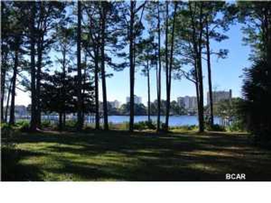 Unheard of these days - 3 acres on the GRAND LAGOON! I think you will agree this is one of the prettiest waterfront lots you will ever see! It is an enormous parcel of land with so many possibilities. Located next to Lagoon Estates, you will appreciate the property even more once you study the parcel map or survey. There is a 3000 sq ft home with fantastic views from so many rooms and angles. People love the North side of the Grand Lagoon because the night skyline includes beautiful condo lights. New Roof in 2012- Storm Shutters --- This is truly a waterfront investment for the future- Don't miss the boat! We were told a minimum of 24 units would fit on this property.