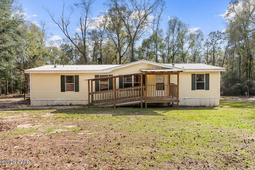 This 4-bedroom, 2-bath doublewide home is situated on over 2 acres in Bonifay and offers a spacious split-floorplan design ideal for comfortable living. Inside, you'll find a large open living room and den featuring a cozy fireplace, creating the perfect space for relaxing or entertaining. The well-sized eat-in kitchen provides abundant cabinet and counter space and is equipped with new appliances. The private master suite includes a large walk-in closet, double vanity, corner garden tub, and a separate walk-in shower. Additional updates include new interior doors throughout the home. Outside, enjoy the covered front porch with a covered entry ramp, offering both convenience and functionality, all set on a generous parcel with room to roam.