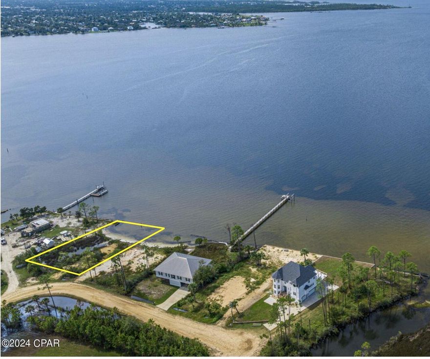 Incredible price on a bay front lot measuring approx 95' x 200'. Live in harmony with nature and enjoy the views from the proposed plans submitted for approval. The Western half of the lot can be contained with a retaining/seawall to construct an elevated, two story home with a 24' x 40' foot print allowing almost 2,000 SF of living space and additional deck space. The plans also include a 285' dock with 12' x 30' covered slip. The small pond adds to the charm and uniqueness of this property. The plans require a minimal amount of fill and maintain the natural condition of the property. Please call for details.  An added plus is that there is no homeowners association. The location is approximately a quarter mile to the West of Bailey Bridge with easy access to shopping, restaurants, businesses and medical care. This incredible opportunity is approx. 12 miles by water from Shell Island, St Andrews State Park and some of the world's most beautiful beaches.