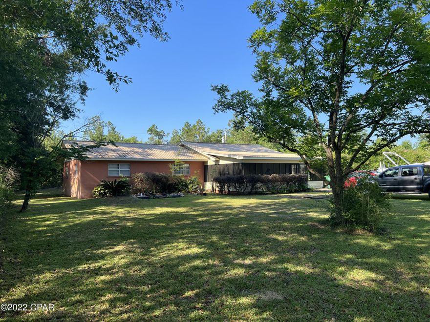 Country Living but close to town. 3/2 CB home approx 6 minutes to Chipley and 50 min to Panama City Fl.  Between Hwy 231 and Orange Hill Rd.  Home boast a large media room with a modern projector for big screen movie viewing.  Master bedroom has a full bath.  Very spacious screened in room for entertaining, under roof this home has nearly 2300 sq. ft.  Inside laundry room with extra space with newer Hot Water Heater. Coy fish pond.