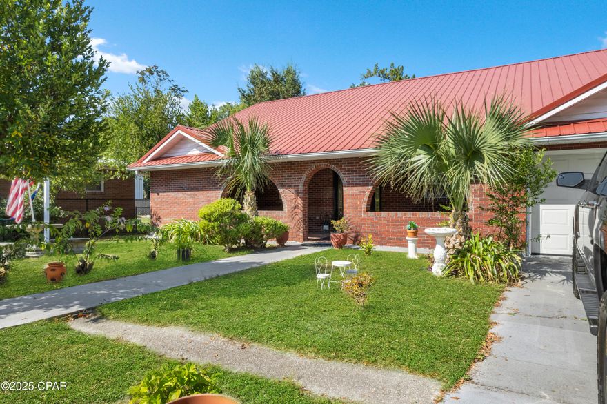 HOME SWEET HOME VIBES — MATURE YARD & INVITING GARDEN — COMFY CURB APPEAL WITH A UNIQUE TWIST Set in the heart of St. Andrews, this home blends character and comfort in all the right ways. Out front, the red metal roof and arched brick porch with ceiling fans bring charm and instant curb appeal, while a semi-circular driveway makes it easy to come and go and provides plenty of space for guests. Inside, vaulted ceilings open the main living and dining areas, creating a bright and airy feel, and the versatile layout includes 3 bedrooms, 2 bathrooms, plus an office. Both baths have been fully remodeled with floor-to-ceiling tile for a clean, modern look, and the primary suite even includes its own additional kitchen—a unique touch that adds flexibility for extended stays or creative use of the space. On a quarter-acre lot, the backyard features a shop/storage shed, and there's side-yard space to park a boat, all while a whole-house generator conveys for year-round peace of mind. All of this is just minutes from historic St. Andrews, downtown Panama City, marinas, and the locally loved dining spots that make this area so special. All information is deemed reliable but not guaranteed; buyer to verify if important.