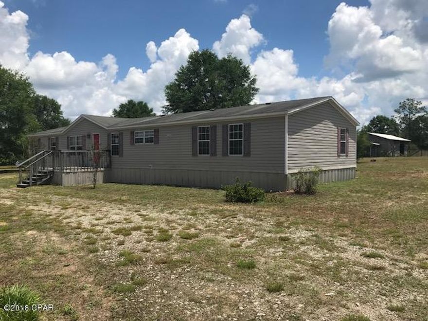 Must see to appreciate this REO property located convenient to town with 7.64 acres. Double wide is well kept and spacious. Kitchen has center counter, lots of cabinets, and D/W.  Large utility room with sink.  Split BR floor plan.  Formal dining room.  Master BR has huge walk in closet.  Master bath has garden tub and shower. Large covered back deck.  Pole barn has 4 stalls with waterers, a tack room and a finished office area with window A/C.  Land all cleared and some fencing.  Property is L shaped and goes from one street to the other.  Privacy fence and cedar trees fronting street gives extra privacy.