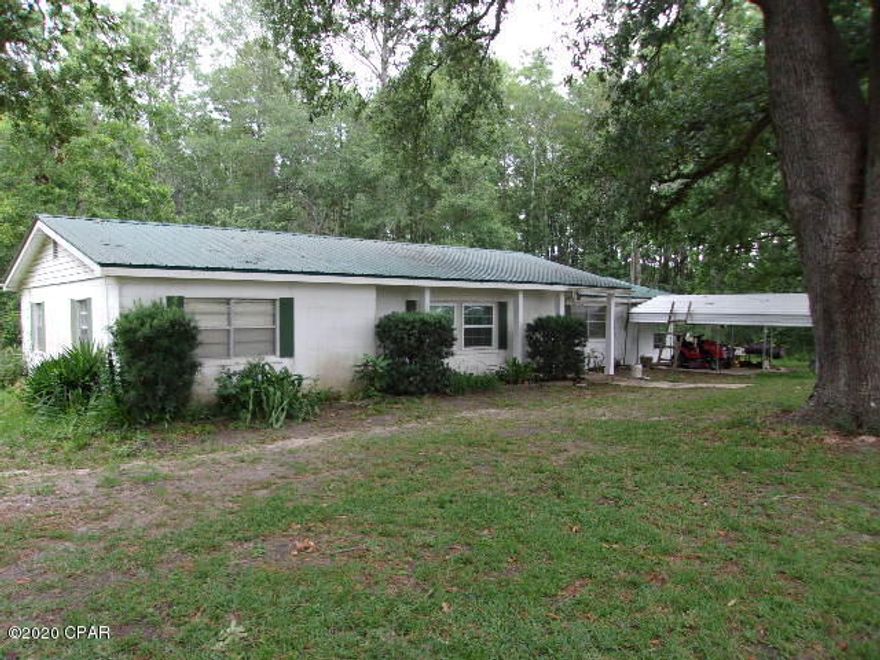 CURRENTLY UNDER CONTRACT SELLER ACCEPTING BACK UP OFFERS - 3 bedroom 1 bath block home on 1 Acre.  Large living room, dining room and large country kitchen with lots of cabinet space. Large laundry room. Split bedrooms.  Florida Room on the back of house. Detached 1 car carport.  New central heat and air system. Metal Roof. Chain link fenced back yard. In the country but very close to county fire department that will help with insurance cost. Pecan trees and beautiful old oaks.  Lots of frontage on paved road. Has a separate septic tank and water line for a mobile home or RV. Check it out today.