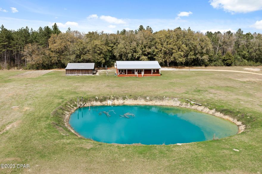 Looking for a place in the country with some acreage... look no further! Custom Brick Home with Metal Roof situated on around 7 acres. Covered front porch. Two bedroom/Two bath home with open floor plan. Master bath has corner tub and separate shower. Property has 12x24 storage building and a 36x54 Barn with 24x36 of space has electric and ac units being used as 2 additional bedrooms and closet area.  Spend your evenings sitting on the porch overlooking the pond.
