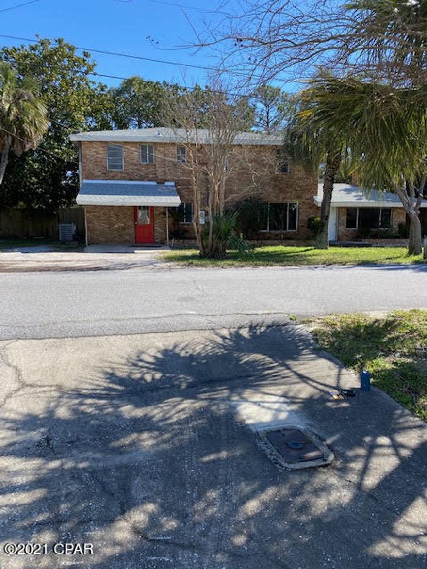 This property is a dream come true for someone.  Main house has 2 bedrooms/2 baths.  There is a separate entrance for another apartment upstairs that is also 2 bedroom 2 baths, with a large deck attached for outdoor pleasure. Back of the property is another apartment that is 2 bedroom 2 baths with a 2 car garage attached.  This lot is huge and .74 acres and only 1 block walk to beach.  House was painted on inside and needs flooring and some repairs.  Central heat and air.  This property is perfect for multiple family members or back apartment could be a great mother in law suite.   Outside is brick so low maintainance.