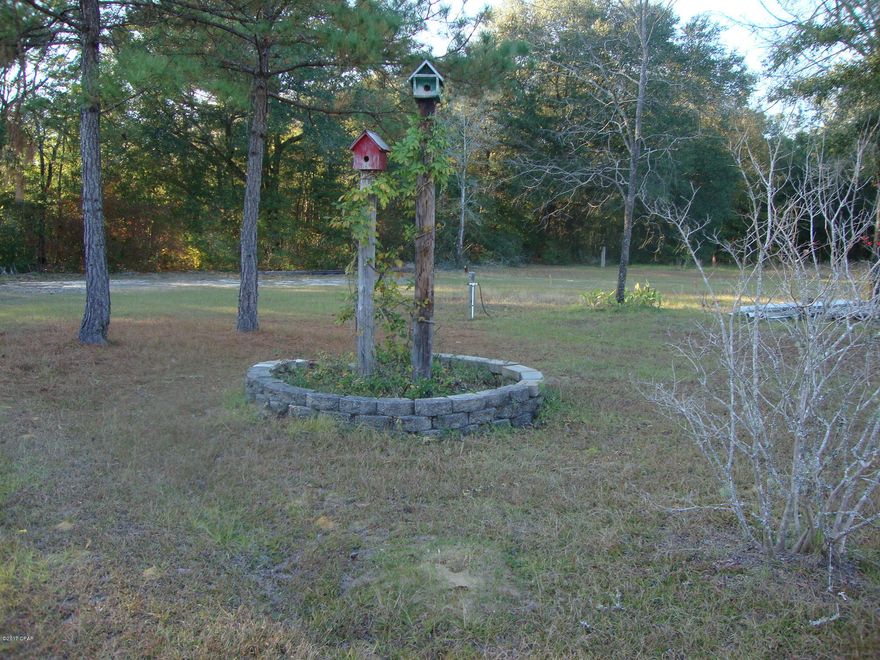 2+ Acre Homesite with well, septic and a liveable old mobile home with no value. Nice circle drive. Land is mostly cleared. Cute fenced serenity area with banana trees and a small decorative gold fish pond. Pole Barn. Frontage on county maintained dirt road just off of paved road and short distance to town.