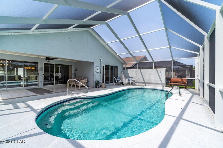 CURRENTLY UNDER CONTRACT SELLER ACCEPTING BACK UP OFFERS - 72 HOUR CONTINGENCY. An absolute treat for the gourmet cook with this gourmet kitchen in this upgraded Glades Patio home with a screened-in heated pool and a 2 car garage. This 3 bedroom 2 bath has had upgrades to every room. This all electric home has a  roof that has solar panels that more than pay for the cost of the panels. The Seller has never had to pay Gulf Power as a matter of fact he has a credit with them at any given time. You are less than a mile to the Beach so a 15 minute walk or a 5-minute golf cart ride takes you to the sugar-white sands of Panama City Beach. The lighting and flooring will wow you on this one. This home has an existing solar panel contract that Buyer will need to assume, more details available.