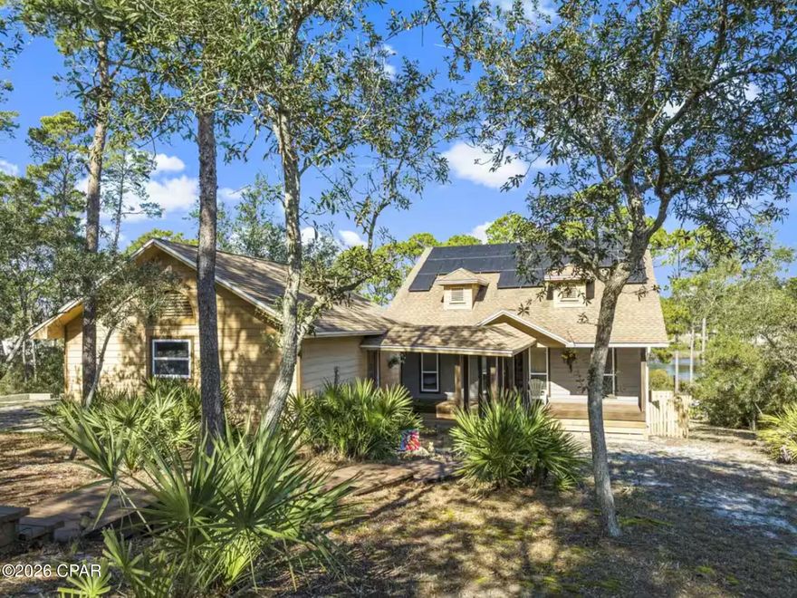 This lakefront retreat offers a rare opportunity to own over an acre of waterfront property with approximately 120 feet of frontage on Lake Powell, one of Northwest Florida's iconic coastal dune lakes. Set on a 1.04-acre parcel, the property provides a sense of space and privacy that is increasingly difficult to find along the coast.

The two-story residence features 3 bedrooms and 2.5 bathrooms with approximately 2,176 square feet of heated living space and 3,300 square feet under roof. The layout is designed to support both personal enjoyment and short-term rental use, with living and sleeping areas positioned to take advantage of the lake setting.

The main level includes two bedrooms, a full bathroom, and a living area framed by large windows overlooking the water. Upstairs, the primary suite serves as a private retreat with a walk-in shower and separate soaking tub. A screened porch extends the living space outdoors, offering a comfortable, covered setting to enjoy lake views throughout the year.

Outdoor amenities include a private dock with walkway and platform, providing direct access for boating, paddleboarding, and fishing on Lake Powell. An outdoor kitchen further enhances the waterfront lifestyle and creates an inviting space for entertaining or relaxing by the water.

Located on the west end of Panama City Beach, the property is just minutes from the Gulf beaches and within close proximity to the dining, shopping, and coastal lifestyle destinations along Scenic Highway 30A. This setting offers a balance of lakefront privacy with convenient access to some of the area's most sought-after coastal amenities. No HOA