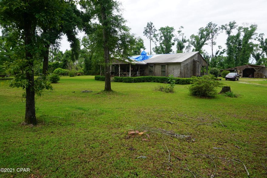 Country living at its best! This acreage offers a small getaway to come home to after a long days work. This home has had some renovations which include a very nice master bedroom, master bath, a large tiled master shower with multiple heads, new kitchen with gorgeous cabinets and wood finishes. The kitchen, dining, and master all have newer laminate flooring. The home needs some roof work to be completed, some sheetrock work on inside ceiling needs repair, crown molding missing, and some other small things. Outside there are two large covered porches on front and the back. Out back there is a large 60'X70' partially closed in pole barn(in need of partial roof repairs) and a smaller 24'X36' pole barn. There is an abundance of wild life with deer constantly walking through the yard.