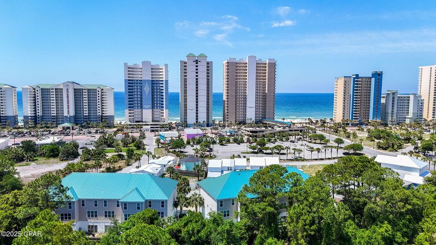 Just one block from the sugar-white sands of Panama City Beach, this spacious three-story townhome offers an incredible opportunity for full-time living, a vacation retreat, or a high-performing investment. Located in the heart of the Long Beach community, this fully furnished end-unit features 5 bedrooms, 4.5 bathrooms, and nearly 2,400 square feet of coastal comfort.

The versatile layout includes a private lockout suite on the first floor with its own entrance, kitchenette, full bath, and bunk beds—perfect for additional rental income or hosting guests. A private elevator provides easy access to all three levels, including the main floor where you'll find a bright and open living, dining, and kitchen area. The kitchen is a standout with bold cobalt blue cabinetry, granite countertops, stainless steel appliances, and a large island with bar seating. Just off the main living area is a guest bedroom with ensuite bath, as well as a covered balcony—ideal for sipping coffee while enjoying partial Gulf views and the breeze off the water.

The top floor showcases an oversized primary suite with a private balcony, soaking tub, and tiled shower, along with two more bedrooms and an additional full bath. This unit is positioned in the building closest to the community pool, adding convenience for both owners and guests.

Located just minutes from local favorites like Pineapple Willy's, The Wharf Buffet, and shopping at Pier Park, you'll also enjoy easy access to mini golf, arcades, and live entertainment. With the beach a short walk away and restaurants within walking distance, the location is ideal for making the most of everything PCB has to offer.

Whether you're looking for a personal beach getaway or a turnkey rental-ready property, this townhouse checks all the boxes.