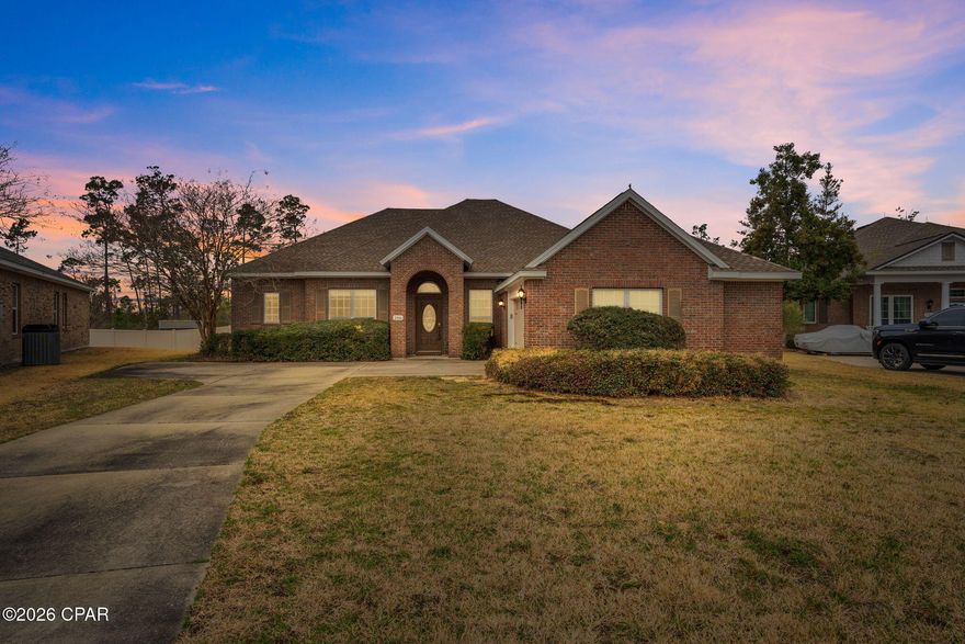 Positioned on a private cul-de-sac lot in the prestigious Hawks Landing community in Panama City, this substantial all-brick 5-bedroom, 4-bathroom executive residence offers 3,605 square feet of thoughtfully designed living space backing to a wooded buffer for added privacy. Built in 2007, the home combines durable construction with generous proportions and architectural detail rarely found in this price range.

Ten-foot ceilings throughout the main level and nine-foot ceilings upstairs enhance the sense of openness and scale. Crown molding, arched openings, and decorative columns add timeless character, while genuine hardwood flooring anchors the primary living areas, complemented by ceramic tile and carpet in designated spaces for comfort.

The main living area offers exceptional gathering space centered around a gas fireplace with built-in shelving and views of the private backyard. The kitchen provides granite countertops, stainless steel appliances, abundant cabinetry, recessed lighting, and a raised breakfast bar that opens seamlessly to the living space, making it well suited for entertaining or larger households.

The oversized primary suite serves as a private retreat with dual granite vanities, a corner jetted tub, and a separate glass-enclosed shower. Four additional bedrooms and multiple full bathrooms provide flexibility for guests, office needs, or multi-generational living. The upstairs bonus room with full bath access adds valuable separation, ideal for a media room or private guest suite.

The covered rear porch extends the living space outdoors and overlooks a backyard with no immediate rear neighbors. The irrigation system operates on reclaimed water, and utilities are serviced through the City of Lynn Haven.

Located within walking distance to Bay Haven Charter Academy and A. Crawford Mosley High School, and convenient to grocery, dining, and retail amenities, this property offers both space and accessibility in one of Panama City's most established neighborhoods.