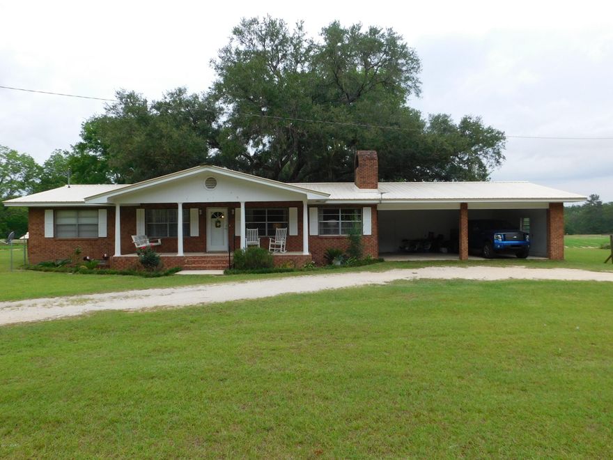 Country Charm with this 3/2 brick home on 14.06 acres. Home has kitchen with newer appliances, laminate flooring, overlooks deck outside, dining area, spacious living room with wood burning fireplace, built in book shelf/tv shelf, laminate flooring. 3 bedrooms, 1 bonus room with a full bath could be the master bedroom or office. Covered front and back porches. Large deck off of back porch shaded by a large oak tree will be great for family gatherings. Laundry area in garage with storage. Circular drive, attached double garage. Outbuilding. Most of the property is clear and approx 10 acres that is in crop. Large pond at the back of the property. Located on paved Hwy. Priced to sell.