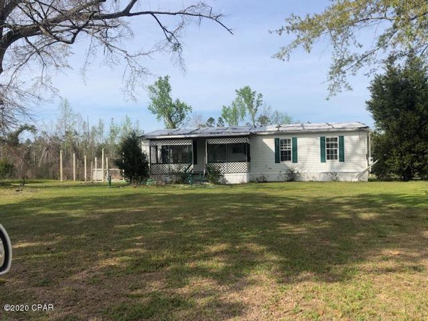 This is a 2 bedroom 2 bath doublewide mobile home on 2.60 acres.  It has damages from Hurricane Michael.  With repairs and updates you will have a neat place in the country.  The living, dining and kitchen area features an open airy design.  It has a covered front porch.  You have room to build a carport and the lot is large enough to have garden and a few animals if desired.