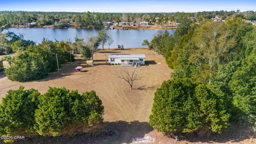 Situated on approximately 1 acre with direct water access, the property features a private dock, stunning lake views, and plenty of outdoor space to relax and enjoy Florida lake life.

The cozy 2-bedroom, 1-bath home has been thoughtfully updated with a newer roof, updated flooring, fresh paint, mini-split system, and a spacious screened porch overlooking the water. Enjoy morning coffee by the lake, sunset evenings on the dock, kayaking, fishing, and the quiet privacy this property provides.

Short-term rentals are allowed, making this an excellent investment opportunity or affordable personal retreat. Conveniently located near Marianna, Panama City, and Dothan while still offering the peaceful feeling of getting away from it all.

If you've been searching for an affordable waterfront property with charm, privacy, and income potential, this is the one.