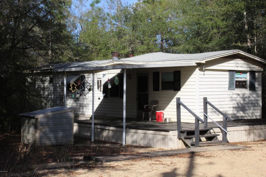 A little piece of Country! Features include an older single-wide mobile home, outbuilding and six wooded acres.  Home is tucked away in the center of the six acres, no visible neighbors offering the home owner privacy.  Call today to see this little Country get away!