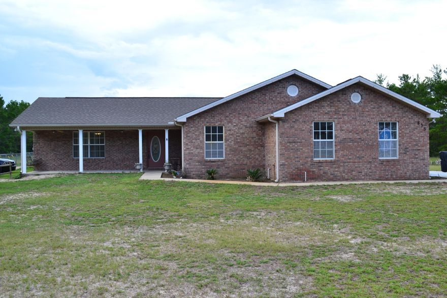 Oh my, you are going to love this wonderful home and the 3.25 acres it sits on from the moment you arrive!  From the lovely covered front porch, enter into the foyer and great room with cathedral ceilings and the custom pallet wall that draws your eye.  This large living area is open to the dining room and kitchen that has plenty of cabinetry for storage.  There is also a roomy pantry.  All appliances including built in microwave and refrigerator remain with the home, even the washer and dryer stay.  There are 3 bedrooms, two full baths, good size closets in each room, and you won't believe the master quite closet - wow!  The a/c and heating unit was replaced in 3/12, roof is a 3 dimensional 30 year shingle, so lots of life left there.  Two car garage with attic storage.  Click more here.. Part of the back yard is fenced for enjoying the outdoors, but then you have all the rest of the acreage to spread out.  There are three storage buildings that convey and a covered carport with one. Lovely newer brick home sitting on over 3 acres, you need to see this one, and it is only a 10-15 minute drive to the mall and Panama City.