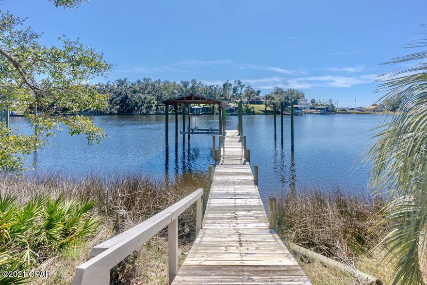 Wow! We love the St Andrews area and we just love this Amazing home! Nestled under the shade of 100 year oak and Magnolia trees sits this Inviting home.The screen porch overlooks your very own oversized waterfront lot which includes an awesome dock,two boat slips and a boat lift. Oh and by the way this water venue has Gulf access.This charming home has many wonderful features such as a front screen porch, a large Florida room ,bonus room,beautiful hardwood floors and a custom kitchen.

The large corner lot has magnificent trees,a detached garage,and  includes the lot on the water. The location is brilliant! Very close to the Historic St Andrews bay area which boats of wonderful Restaurants,quaint shops and local  activities.Jump in your boat and be at Shell Island in only minutes.Come enjo