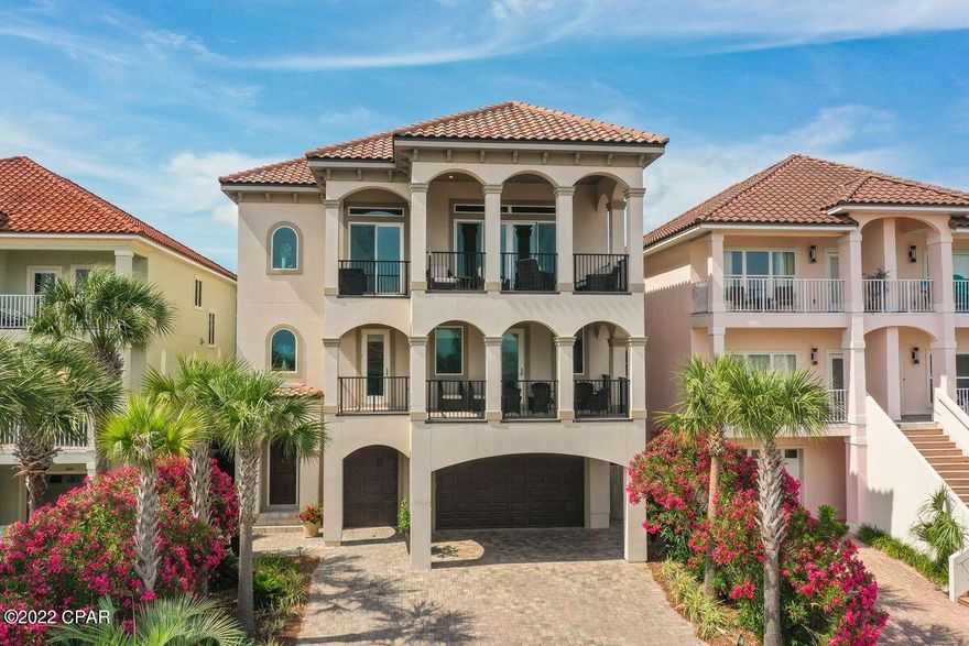 Built in 2017, this immaculate home enjoys gated security, deeded beach access and all the benefits of living in the community of La Valencia Beach Resort. The reverse floor plan takes full advantage of the stunning gulf views with three floors of living space and an elevator to get you there. Lime oak flooring on the upper floors, 10-ft. or 12-ft. ceilings, extensive built-in storage, impact-resistant windows and under/over cabinet lighting provide added benefits. Relax and entertain in the third-floor great room around the feature gas fireplace or step out onto the covered lounge deck and show off those breathtaking views. It's the perfect spot for sunset cocktails before moving into the formal dining area for a social feast. The gourmet kitchen with a 6 burner gas range, double ovens and stunning quartz & granite countertops is a well-planned space for home chefs to create memorable cuisine. Sharing the same rooftop views, the master suite includes a sumptuous ensuite bath with dual vanities and walk-in closet. Down one level, there's versatile recreation space in a family room that includes a beverage nook, seating area, kitchen and drinks cooler. Three beautifully proportioned bedrooms include a second master suite. The first floor has a family room with a sleeper sofa for guests that could easily become an extra bedroom. A studio kitchen with refrigerator is well-located for delivering chilled drinks straight to backyard lounge chairs and the outdoor kitchen. There's bunk room potential in the private office space and a three-car garage plus separate golf cart garage. This coveted beach community is a golf cart ride from shops and restaurants on the west end of Panama City Beach. Rosemary Beach and 30A entertainment and lifestyle are two miles away. Whether it's a full-time residence, or a second home, owners have the privilege of enjoying an owners only pool. Owners and guest a like always enjoy tennis courts and a beautiful gulf-front pool and deeded beach. La Valencia Beach Resort is truly a hidden gem.