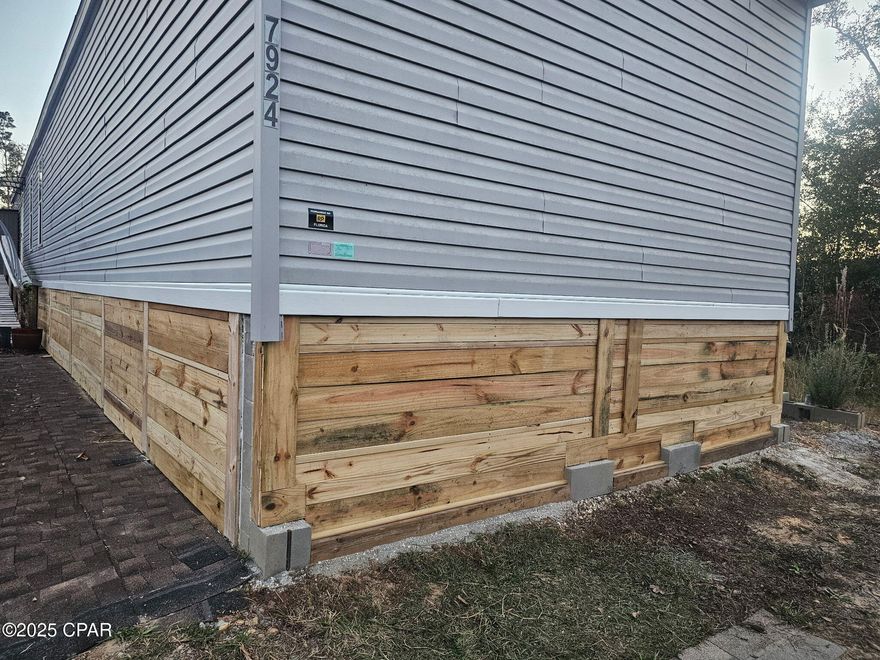 Welcome to a fantastic opportunity to own a well-maintained single-wide home in a sought-after location on almost 5 Acres. Discover modern living in this beautifully laid out single-wide home. This home is ideal for those seeking a quiet neighborhood with easy access to everything you need. Step into a bright, airy, open concept living space where natural light floods the main areas, creating a welcoming atmosphere. The kitchen features upgraded appliances and an island bar. The private master suite offers a tranquil retreat, complete with a walk-in closet.

A home with a multigenerational homesite or additional income, this dual-purpose property allows for different arrangements. Living in one house and renting the other for income or a separate but close home for a family member. The second home is wired and plumbed, ready for sheetrock and flooring with newer roof and solid foundation.

The homesite sits on 4.29 Acres mostly wooded that backs up to a winding, wide mouth creek, an oasis for relaxing and fishing. Trees surround the house for privacy and a country feel, just minutes from Panama City 23rd Street, Tyndall AFB and much more! Close enough for a quick trip to the beach, but enough distance to avoid seasonal traffic. A beautifully well cared for Public-park with 5 ball fields, picnic area and playground for the kids minutes away!

The home has been well-maintained, and some features have been upgraded. A list of items: Septic Inspected & riser installed 2022, Well sealed for intrusion 2024, Electrical underground service 2022, Mini split unit installed 2022, Whole-house water filter installed 2022, Appliance Upgrade 2023, Master shower fixture upgrade 2025, Main entrance door widened from 32'' to 36'' solid fiberglass, Ramp installed 2023, Living room fan upgrade 2024 Custom wood underpinning 2025. CUSTOM SKIRTING COMPLETE!

This turn-key property awaits you and won't last long! Call today to make this your new home. Buyer and Buyers agent to verify all dimensions and anything deemed important.