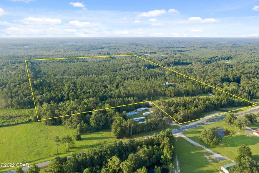 CURRENTLY UNDER CONTRACT - SELLER WILL CONSIDER BACKUP OFFERS!  A BRAND NEW WELL, A 911 ADDRESS,  LARGE ACREAGE and PAVED ROAD FRONTAGE! - Here's the parcel you've been looking for that checks off the boxes. This beautifully wooded property has planted pines, a couple of cypress ponds, a small stream at the SW corner of the property and is partially cleared for your new home.  As an added bonus, the property has already been surveyed! There is a gas pipeline easement on the property.   Access to the property can be at the pipeline gate or to the left of it on the other side of the holding pond.  Don't miss out on this one - contact your favorite realtor today!