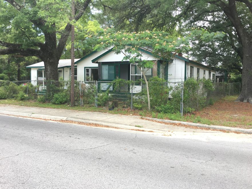 Traditional styled home with large fenced yard ,large yard building and large shade trees all situated on a corner lot. The house is L shaped has both a living and large family room and covered front porch.