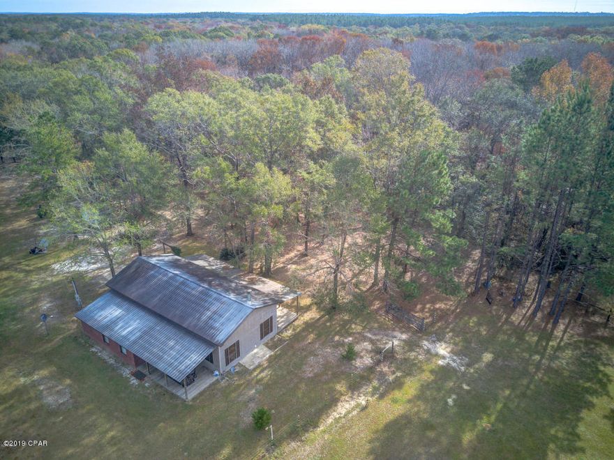 CURRENTLY UNDER CONTRACT, SELLER ACCEPTING BACKUP OFFERS. This gorgeous one of a kind country home sits on approximately 20 acres of lush land with huge hardwoods, Oaks, Hickory, and Cypress trees.  The beautiful property has approximately 500ft of creek frontage and lake frontage on an open fish filled lake that feeds directly into Historic Homes Creek. Bordered by Water Management on three sides, there is wildlife galore!  The house has a new HVAC installed June 24, 2019, new well installed in 2017, and a new refrigerator that hasn't been used and under warranty. Next door is a partially finished house with slab, interior walls framed, septic tank & well, and has been wrapped. This can easily be completed. 

	

Located near the quaint town of Vernon Florida in Washington County, it is th perfect place to retire or be a hunter or fisherman's retreat. The beautiful rolling 20 acres sits at the end of the cul-de-sac and is surrounded by hundreds of acres of water management property on giving you ultimate privacy to explore or hunt. The private community offers a private boat ramp or you can use your very own boat ramp located in your own gorgeous picturesque park area on the property sitting at Holmes Creek's edge that features a creek side custom built rope swing stand. 

Enjoy this very private two bedroom two bath, 1470 square foot home where peace and quiet is abundant. Not only is your home located in the quiet quaint country and off the beaten path, but it also is only a 35 minute drive to the beautiful famous white sandy beaches of Panama City Beach Florida, 20 minutes to interstate I-10, and only a 10 minute drive to Vernon which has shopping and restaurants.

Originally built in 2003 as a one bedroom home, a second custom master suite was added to the home by the present owner that is a General Contractor. The custom master bedroom and bath built in 2015 is bricked in, with a half vaulted ceiling, a beautiful hunter fan, custom skip drag ceiling, mahogany Pergo flooring, closet, and private bathroom. The all tile bathroom has a large oversized jetted Jacuzzi bathtub with custom Koehler handles and shower nozzle. The new Kohler toilet is top-of-the-line in water saving efficiency. The bathroom boasts a large beautiful mahogany vanity with travertine top to fit all your needs and custom mirror. There is even a space hardwired with power and HDMI for your flat screen television right next to the Jacuzzi tub to watch as you lounge in the suds. The house is also equipped with a backup generator and its entire panel including breakers that are labeled.

Sitting off of the master bedroom is the oversized 20X25' living room with 10 foot walls and vaulted ceiling, gorgeous hardwood floors, custom wooden Levelor blinds, and a giant 58 inch flat screen TV. In 2016, the Seller added a custom built 42 inch real log fireplace surrounded by an emerald green Italian marble hearth to enjoy on those cold late winter evenings. The living room also has 2 Klipsch background speakers and whole living room is wired for a 7 channel stereo. Outside of home is wired for 6 security cameras encompassing all 4 corners as well as the front and back porches.

Off of the living room sits a large tiled kitchen. The new large Whirlpool refrigerator freezer with French doors and bottom pullout freezer that is still under warranty and never been used. The kitchen has a built-in dishwasher, Stove& oven, integrated microwave, and custom hardwood cabinets for all your storage needs. There is also a handy island bar with stools.
The second bedroom, behind the kitchen,  includes large closet spaces, custom wooden Levelor blinds, brand new laminated hardwood floors( installed October 2018), and an enclosed laundry room that comes with washer and dryer. The bedroom also has custom built pulldown stairs which lead to the attic space above to provide an even more storage!  

The main bathroom also has custom hardwood cabinets and an enclosed water softener unit. The house is on a septic tank which was serviced in 2017.

Off of the front door sits a large 12 x 24 open covered porch that looks onto the beautiful electric fenced pastureland and large grassed front yard. The huge 12'X48.2' covered back porch awaits your Teak rocking chairs (included) is perfect for purveying the backyard which slopes down to more beautiful Hardwoods and old growth. You can even BBQ on your own custom iron barbecue grill right from the comfort of your backyard and watch the deer, birds, and critters play.

The property also has an aluminum shed with window, to house all of your tools and gear.  It is an 8ft x10ft enclosed shed with one side that is covered where you can pull in your tractor, ATV, lawnmower, or boat. There is even a camouflage color, 16' above ground pool to cool you off on those hot balmy days which is ready to roll for the new upcoming year.

This property is available now. You don't want to miss this opportunity. This is one rare find!