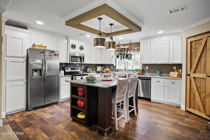 CURRENTLY UNDER CONTRACT, SELLER WILL CONSIDER BACKUP OFFERS

Welcome to peaceful country living at its finest. This beautifully maintained 2021 mobile home features 4 bedrooms and 2 bathrooms, perfectly situated on 5 sprawling acres in the heart of Chipley, Florida. From the moment you arrive, you'll appreciate the wide open space, private driveway, and beautiful setting—ideal for those seeking a country lifestyle with room to grow.

Inside, you'll find approximately 2,280 square feet of well-designed living space. The home offers a welcoming living room with a tray ceiling, rustic barn doors, and plenty of room for relaxing or entertaining. Nearby, the spacious family room features a cozy wood-burning fireplace and large windows that fill the space with natural light, creating the perfect spot to gather with loved ones.

The kitchen is a standout with granite countertops, a center island, stainless steel appliances, a walk-in pantry a stainless steel farm sink, and custom cabinetry that blends functionality with farmhouse style. Just off the kitchen, the formal dining area provides the perfect space for hosting family and friends.

The split-bedroom floor plan offers maximum privacy, with the spacious primary suite located on one side of the home. The additional three bedrooms are situated on the opposite end, surrounding the family room—making it a great retreat or play space for children and guests. 

Step outside to enjoy the benefits of country life with 5 acres of open land—ideal for animals, a garden, or future expansion. A large pole barn, storage shed that is plumbed for bathroom fixtures, and ample parking provide the space and storage you need for work or play.

Conveniently located less than an hour from Panama City, Panama City Beach, and Northwest Florida Beaches International Airport, and approximately one hour from Dothan, Alabama, this property offers the perfect balance of peaceful rural living with easy access to coastal fun, travel, and city conveniences. 

Whether you're looking to start a homestead or simply enjoy more space and privacy, this home checks all the boxes.