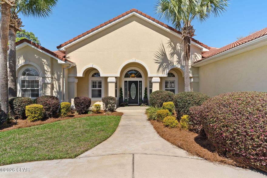 Step into effortless coastal living in this beautifully maintained 3-bedroom, 2.5-bath golf course home, complete with a flexible space ideal for a home office or additional living area, tucked inside the gated community of Emerald Bay. Perfectly positioned along the 5th fairway on a premium lot, this home is set back from the road with a circular driveway, offering both privacy and generous parking that's a rare find in the neighborhood. Inside, soaring 14-foot ceilings, tray details, arched openings, and plantation-shuttered windows create a bright, airy feel throughout. The thoughtfully designed layout flows with ease, offering both a formal living room and a second living area featuring a gas fireplace and custom built-ins that is ideal for both relaxing and entertaining. The kitchen is as functional as it is inviting, with granite countertops, stainless steel appliances, a prep island, under-cabinet lighting, tiled backsplash, and custom cabinetry for storage. The primary suite offers a true retreat, complete with a sitting area and private access to the covered lanai. The en suite bath features a jetted tub, separate shower, dual vanities, a private water closet, and two closets, including a walk-in. Designed with everyday comfort in mind, the home also includes a laundry room with utility sink and cabinetry, central vacuum throughout, and an oversized 26x20 garage with a side access door. Enjoy sweeping golf course views from nearly every room, as the main living areas and primary suite open seamlessly to the outdoor space. The expansive 43-foot screened lanai creates the perfect setting to unwind or entertain while overlooking the fairway, bridge, and tranquil water feature. Freshly painted and truly move-in ready, this home offers a turn-key opportunity in one of the area's most sought-after communities. Located in an X flood zone with a low HOA, Emerald Bay provides access to golf, a clubhouse, tennis courts, and a community pool--all just minutes from shopping, dining, and the beach.