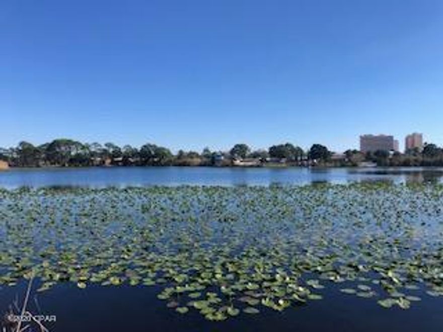 CURRENTLY UNDER CONTRACT, SELLER ACCEPTING BACKUP OFFERS. Directly across the street from the white sandy beaches and turn key!  Located on beautiful Lake Lullwater, close to Pier Park,  this 2BR/2BA condo is the definition of coastal chic!  Completely gutted and redone in 2017!  Plank vinyl tile, granite, custom shiplap, hood vent, smooth top stove and more!  Vacation Rentals allowed!  You won't find a better buy at this price!