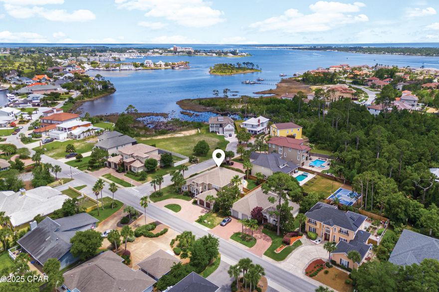 Refined, intelligent, and purposefully crafted for effortless coastal living, this custom four-bedroom plus office residence in the prestigious Bay Point community is a statement of modern sophistication. Towering nearly 30-foot ceilings set the tone for the expansive, open-concept living spaces, where tranquil water views and curated luxury upgrades deliver a sense of serene indulgence.

The chef's kitchen, completely reimagined in 2022, is both beautiful and functional—featuring custom cabinetry, sleek new countertops, a spacious walk-in pantry, and a premium three-stage reverse osmosis filtration and remineralization system. Designed with entertaining in mind, the home includes integrated indoor/outdoor speakers, all-new LED lighting, and a smart-home system with cameras, door sensors, and programmable thermostats for optimal comfort and security.

Step outside to a private oasis, where a resurfaced saltwater pool (2023) with gas heating and stylish tile complements the fully remodeled outdoor kitchen (2025)—perfect for hosting under the Florida sun. Every bathroom in the home has been professionally renovated, with the upstairs and primary baths completed in 2025. The primary bath offers a spa-quality experience with dual high-end shower systems, body sprayers, rain heads, and hand wands.

Additional enhancements include a newer roof installed in 2021, a whole-home tankless water heater added in 2023, and two new HVAC systems replaced in 2023 and 2024. The property also features a Wi-Fi-enabled irrigation system, a generator hookup, a luxury vinyl privacy fence (2024), and a Tesla 40-amp charger. A 2009 EZGO golf cart is included with the home.

Situated within the gated enclave of Bay Point—home to one of Panama City Beach's only full-service marinas—residents enjoy 24-hour security, golf, tennis, and impeccably maintained grounds. This residence offers a rare blend of resort-style amenities and practical luxury, perfectly suited for discerning homeowners who value excellence in every detail of their living environment.